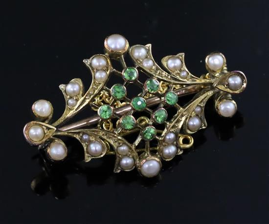 An Edwardian gold, split pearl and demantoid garnet set brooch, 32mm.